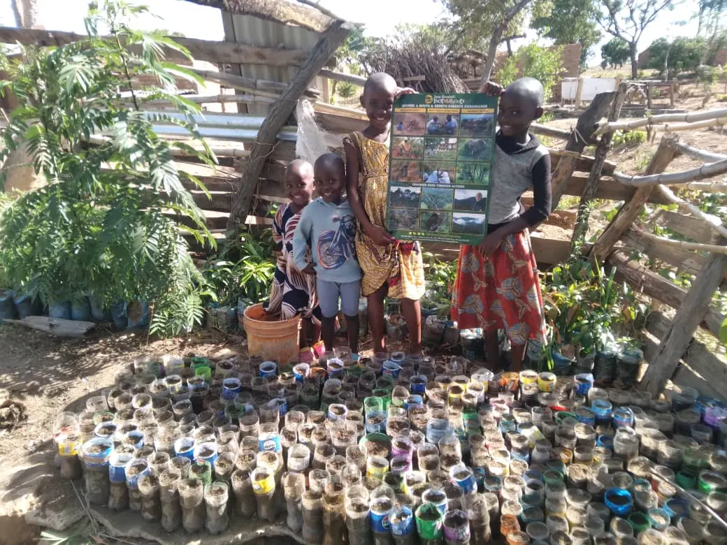 Children tending a garden grown in reused plastic containers